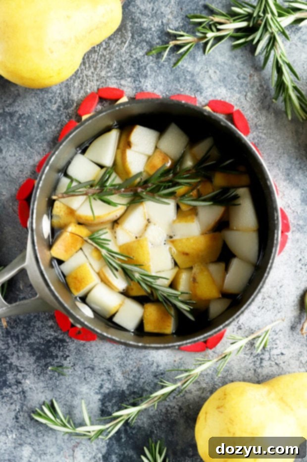 Aromatic Pear Rosemary Gin and Tonic 6 Pear and rosemary steeping in simple syrup within a saucepan.