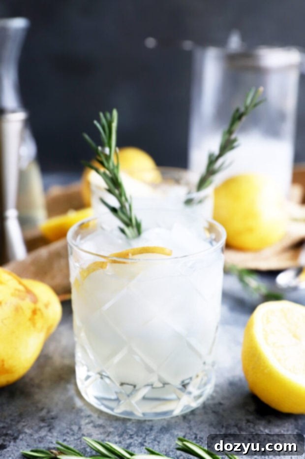Aromatic Pear Rosemary Gin and Tonic 9 Single Pear Rosemary Gin and Tonic in a glass, highlighted with fresh garnishes.