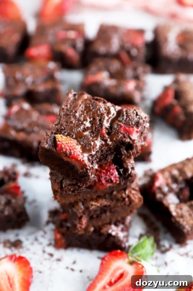 Velvet Berry Chocolate Brownies 8 Stack of chocolate brownies with a peek of strawberry