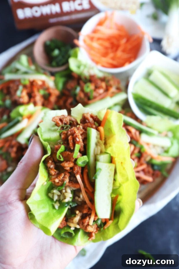 Hand holding a finished Korean turkey lettuce wrap against a blurred background