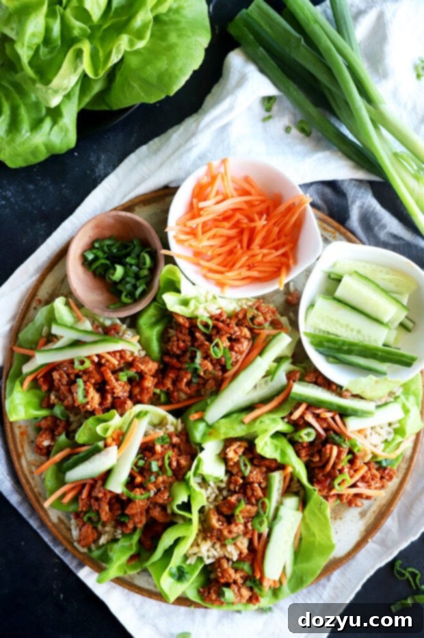 Overhead image of assembled Korean turkey and rice lettuce wraps on a wooden board