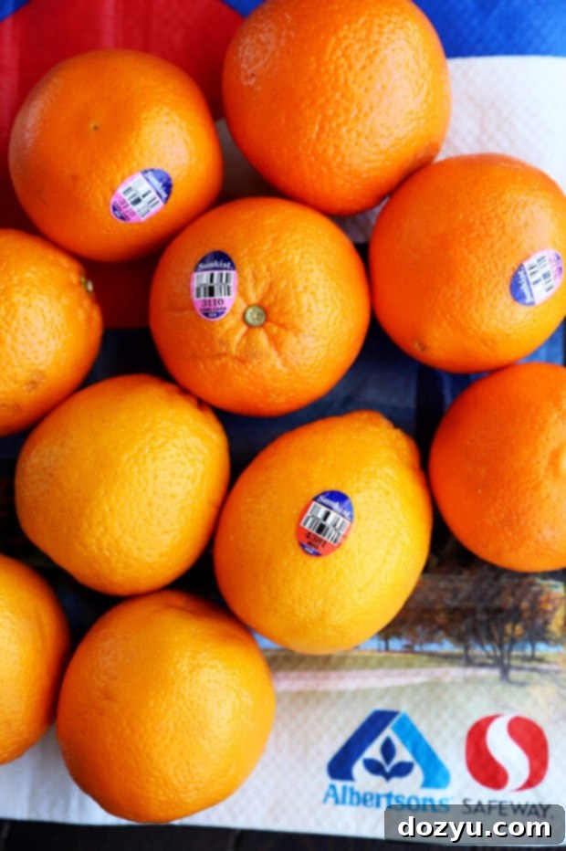 A vibrant display of whole Sunkist Blood Oranges and Cara Cara Oranges, some halved, showcasing their appealing colors and textures, ready to be picked from the produce section.