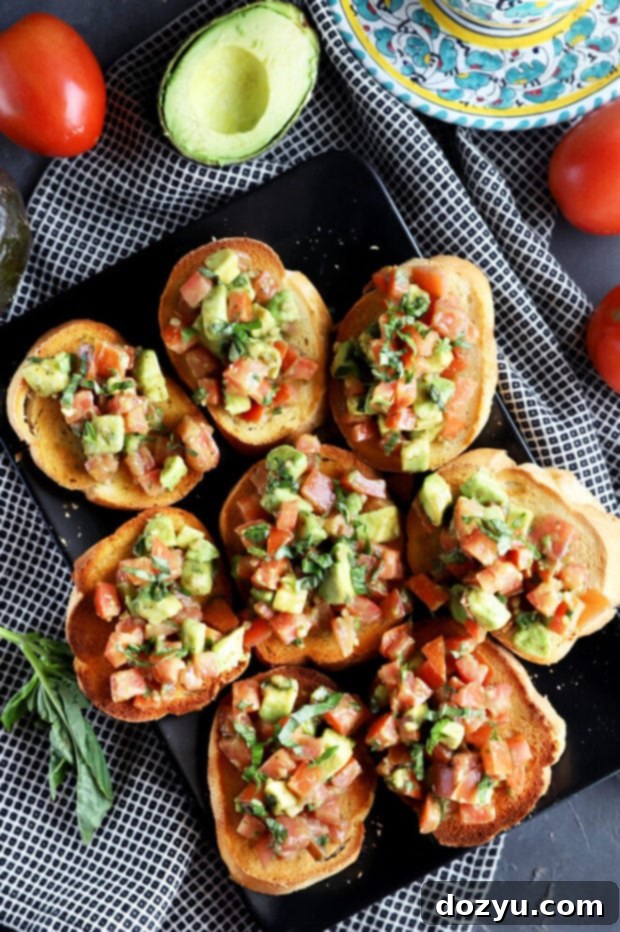 Overhead photo of avocado bruschetta on a plate, ready to serve