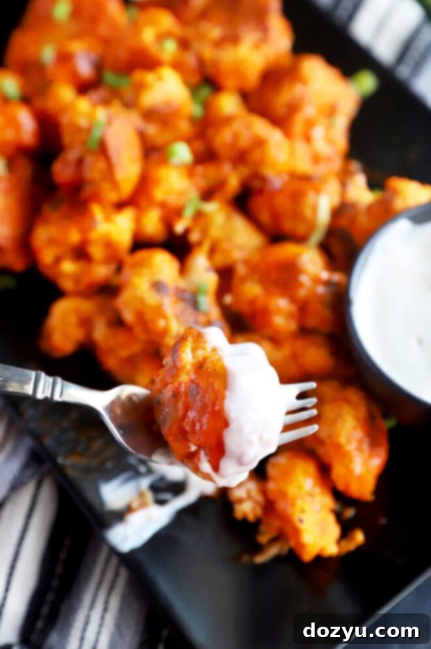 Buffalo cauliflower dipped in sauce, ready to serve
