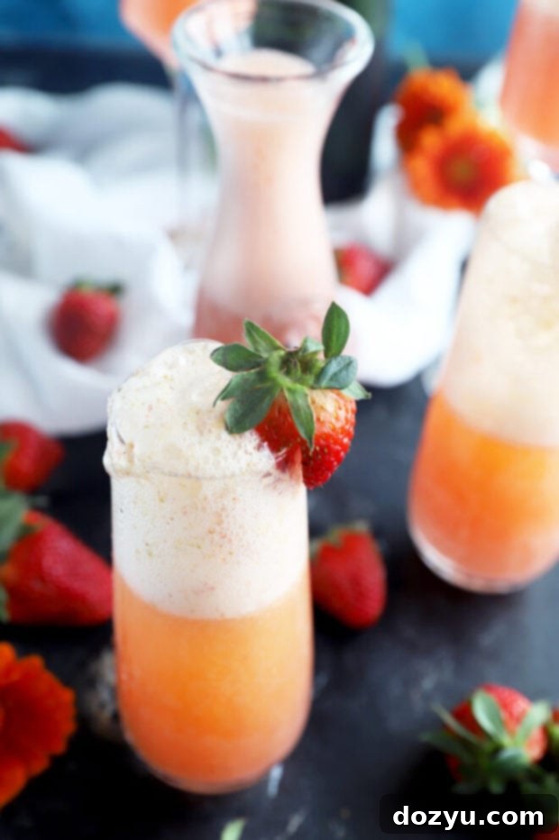Strawberry Sparkler 6 Overhead view of two strawberry mimosas with a pitcher of strawberry-orange mixture