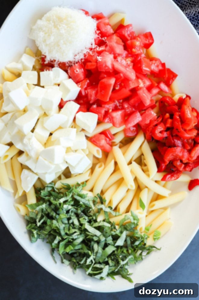 making summer lemon pasta salad in a large bowl with fresh ingredients