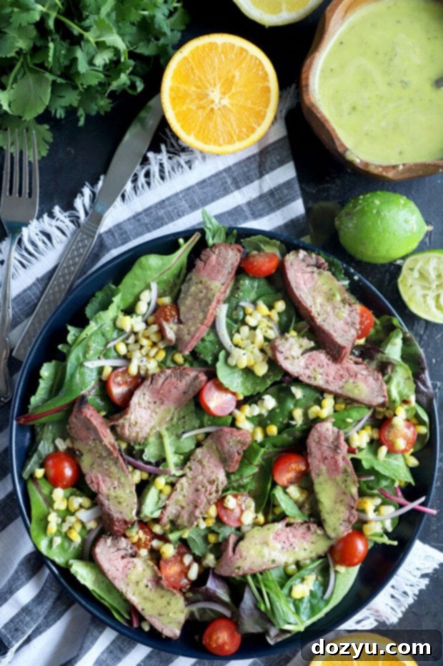 Photo of mojo steak on greens with corn