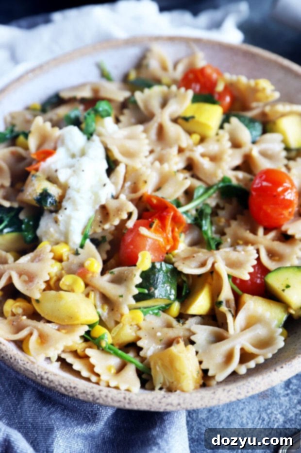 A close-up shot of farmer's market pasta in a rustic bowl, showcasing the fresh vegetables and creamy ricotta.