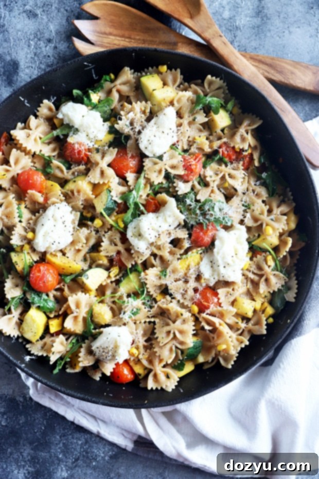 Overhead photo of veggie pasta, showing a generous serving with fresh herbs and cheese.