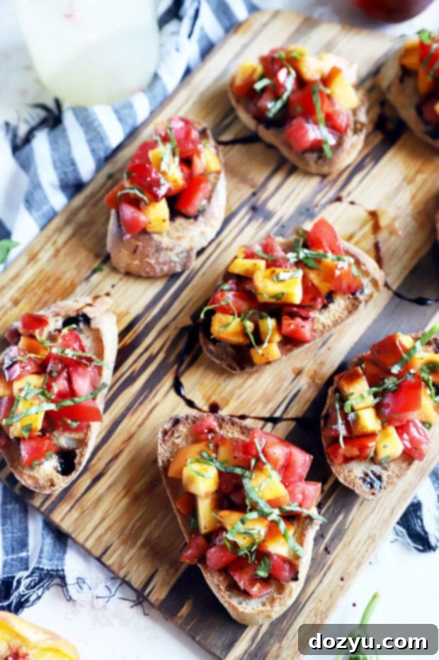 Overhead photo of multiple Tomato Peach Bruschetta appetizers on a wooden board.
