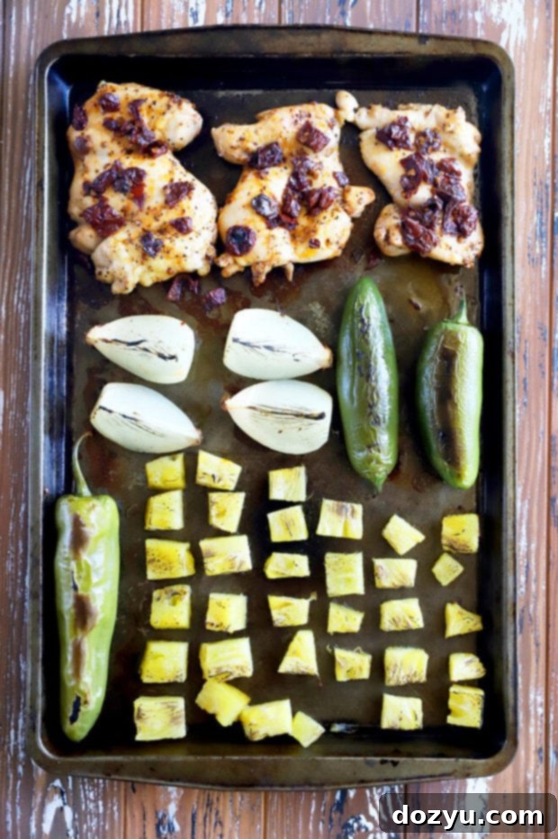 Roasted chicken, pineapple, peppers, and onions on a sheet pan, just out of the oven.