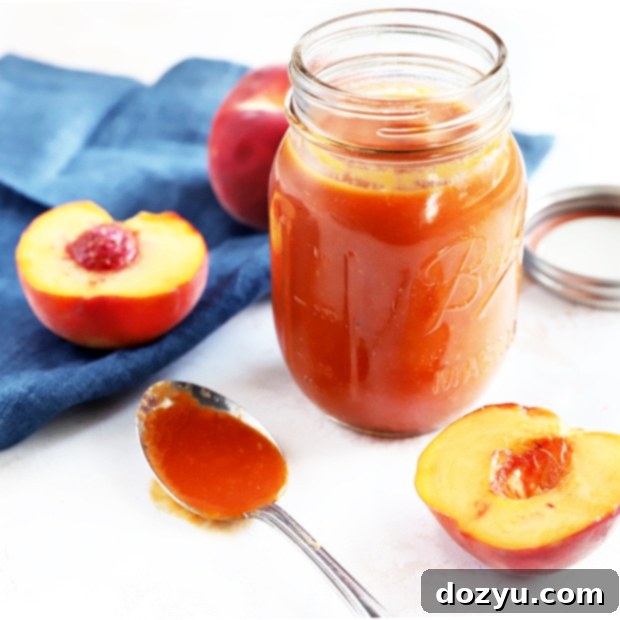 Homemade Bourbon Peach BBQ Sauce in a jar with fresh peaches.