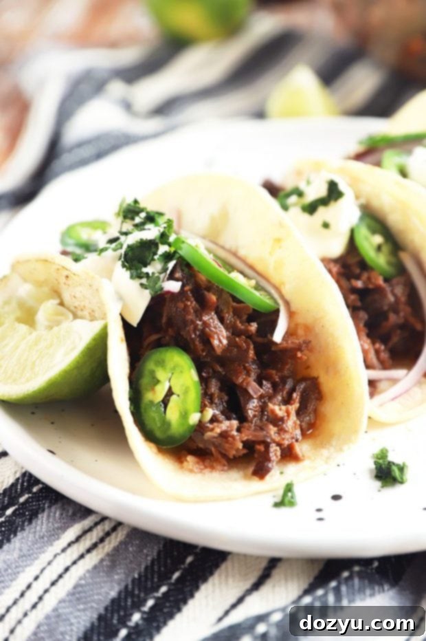 Beef tacos cooking in an Instant Pot, showing the short ribs braising in sauce