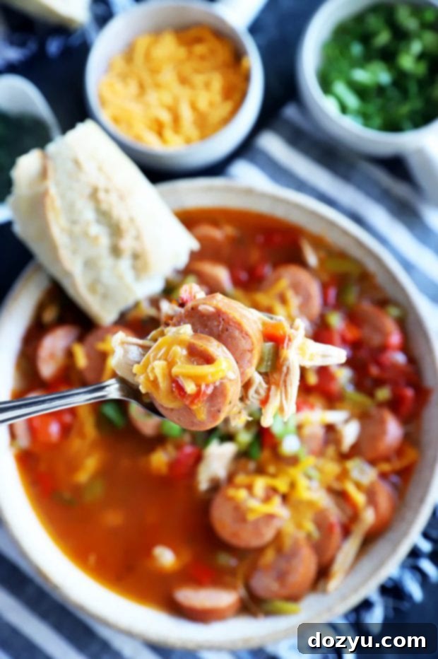 Instant Pot Louisiana Chicken Sausage Soup 3 A spoon lifting a scoop of Instant Pot Creole Chicken Sausage Soup from a bowl, showing the rich texture.