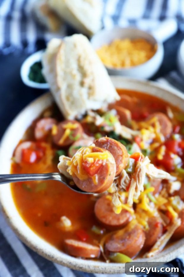 Instant Pot Louisiana Chicken Sausage Soup 6 A closer shot of a spoonful of creamy Creole chicken sausage soup, highlighting the ingredients.