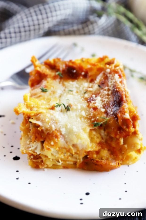 A slice of Freezer Spicy Herb Pumpkin Lasagna on a plate, garnished with fresh herbs