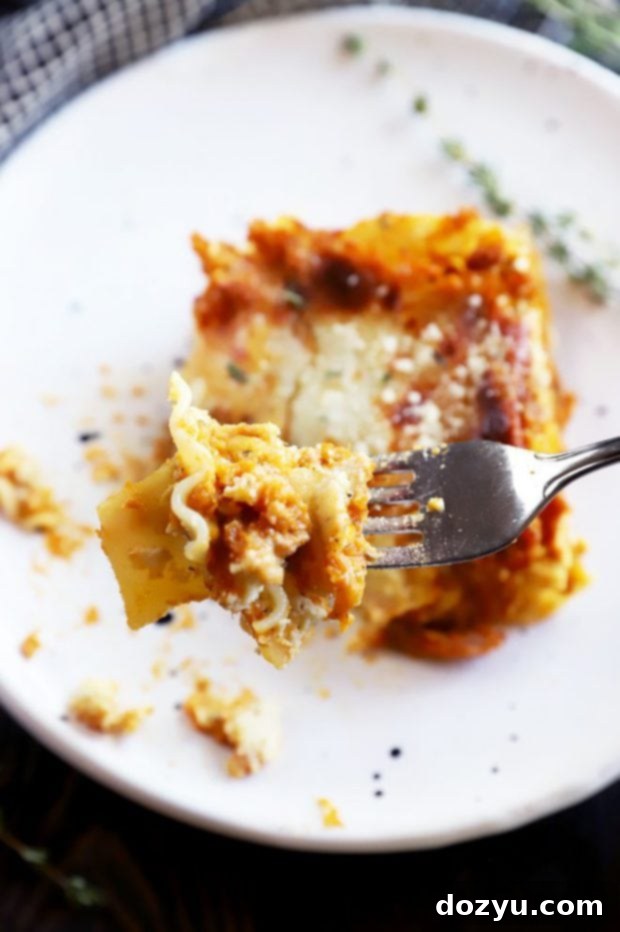 A fork taking a bite of Freezer Spicy Herb Pumpkin Lasagna, highlighting its texture