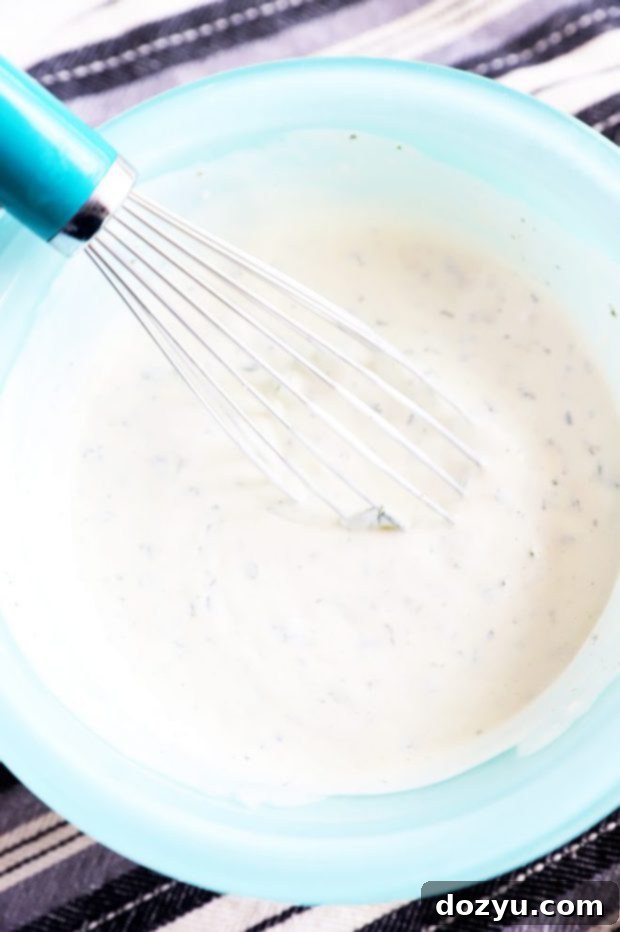 Small bowl of creamy cilantro dipping sauce with a whisk resting in it