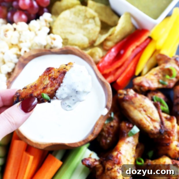 Close-up of the Ultimate Tailgating Snack Board featuring wings and dips