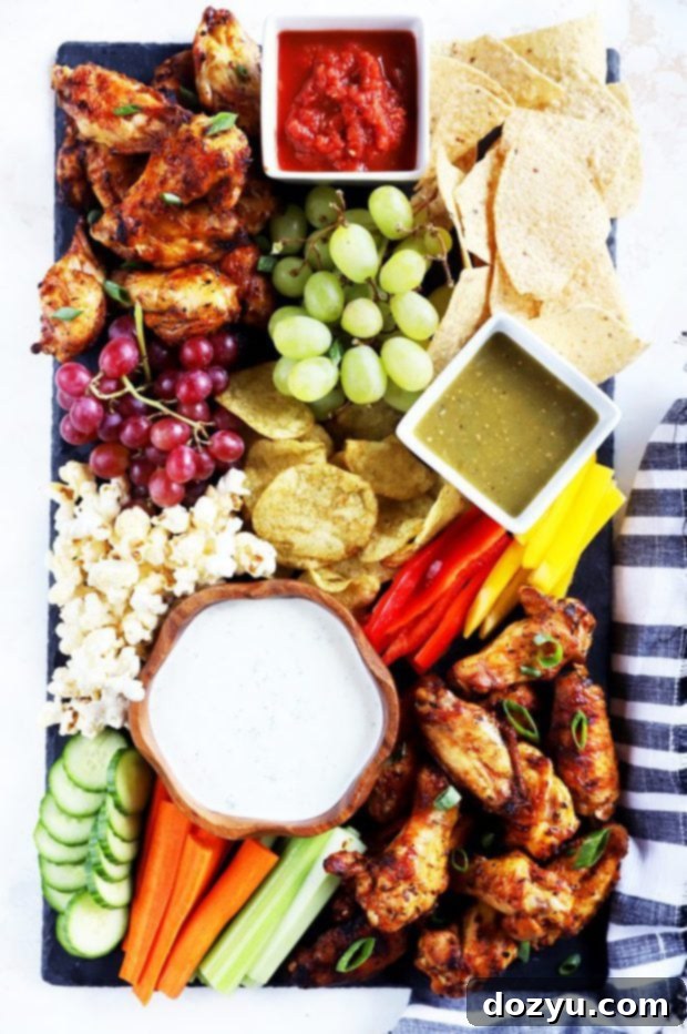 Overhead photo of the ultimate tailgating snack board, arranged attractively with wings and accompaniments