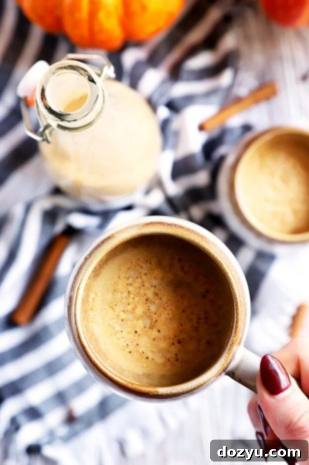 Hand holding mug of pumpkin coffee picture