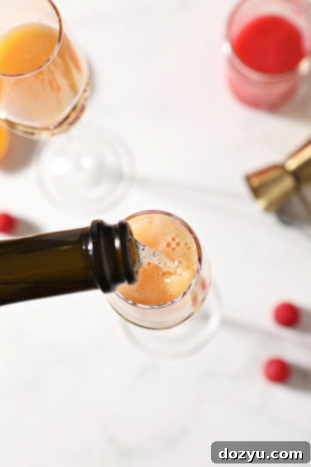 Brunch Bliss Raspberry Mimosa 7 Champagne being poured into a glass with raspberry simple syrup and orange juice