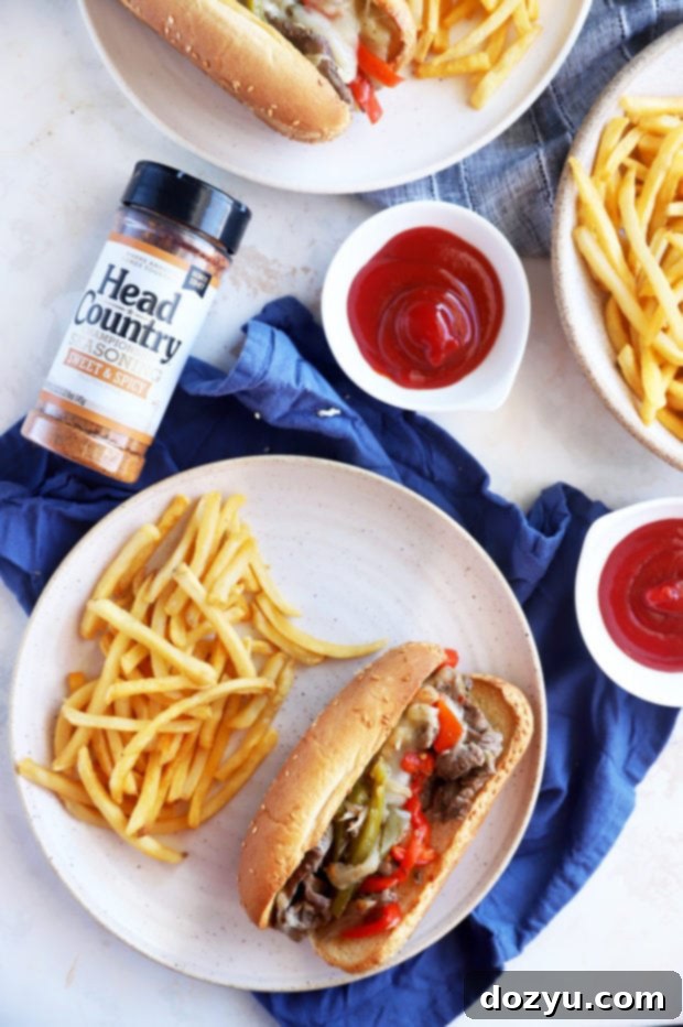 Head Country seasoning bottle with delicious Philly cheesesteak sandwiches on plates, ready to be enjoyed.