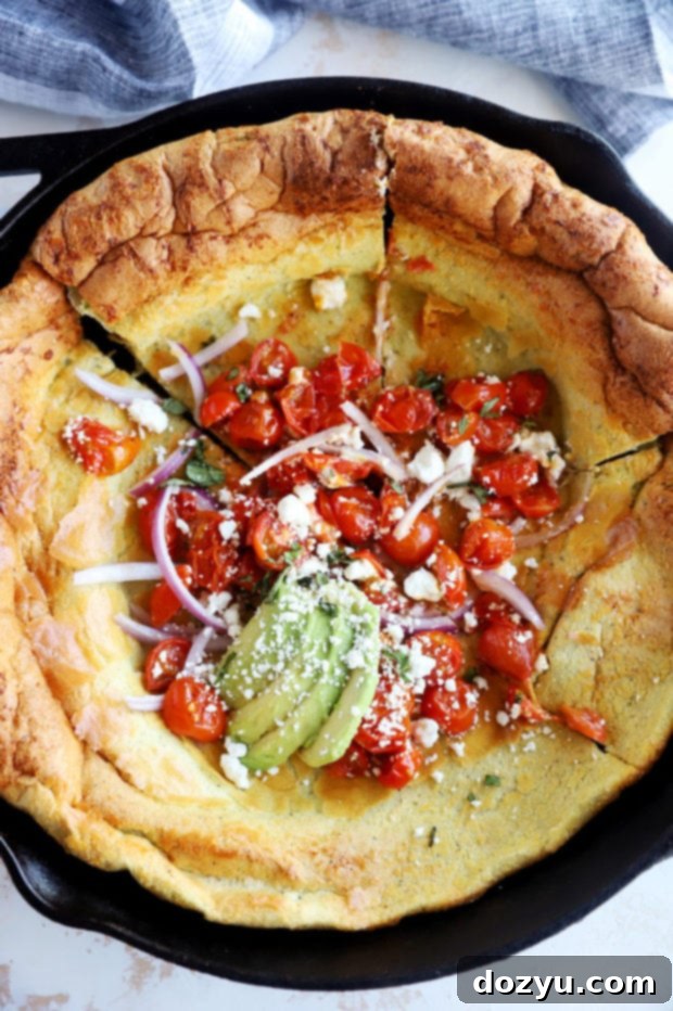 Savory Dutch Baby Bake 5 Close-up of a perfectly puffed savory Dutch Baby in a cast iron skillet, ready to be sliced.