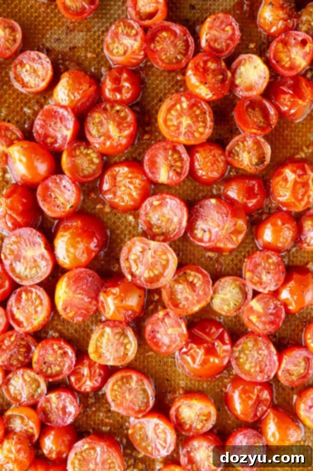 Savory Dutch Baby Bake 6 Halved cherry tomatoes tossed with olive oil, salt, and pepper on a baking sheet before roasting.