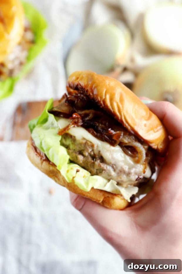 Hand holding french onion burger