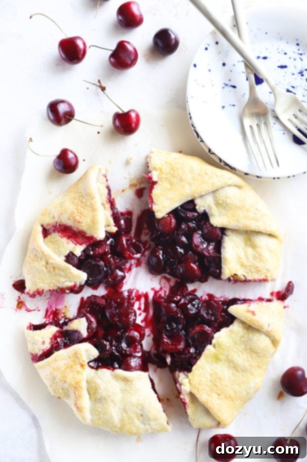 Overhead image of a beautifully sliced homemade galette, revealing the juicy cherry filling and golden crust