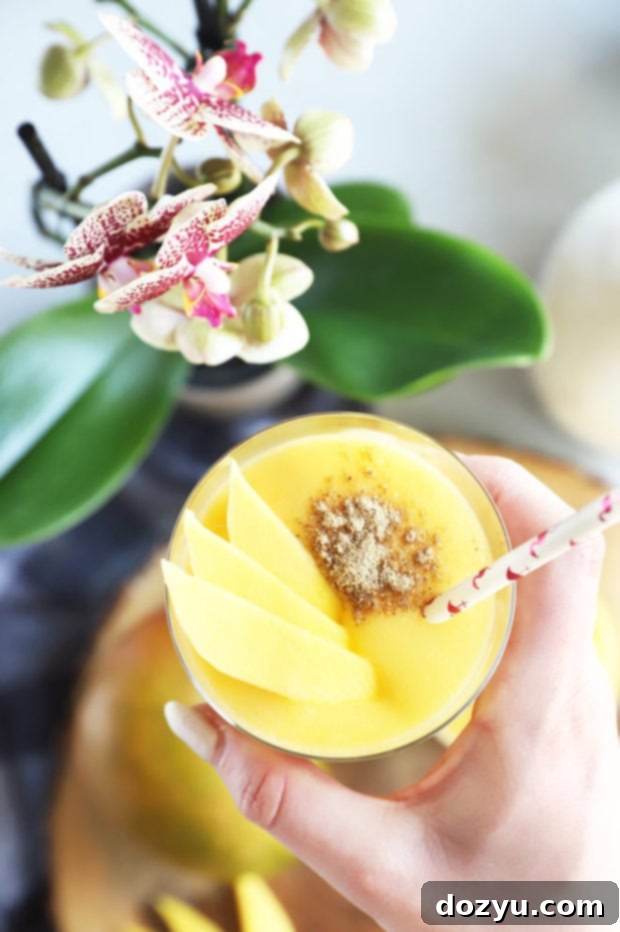 Tropical Mango Coconut Bliss 4 Hand holding glass of coconut lassi image