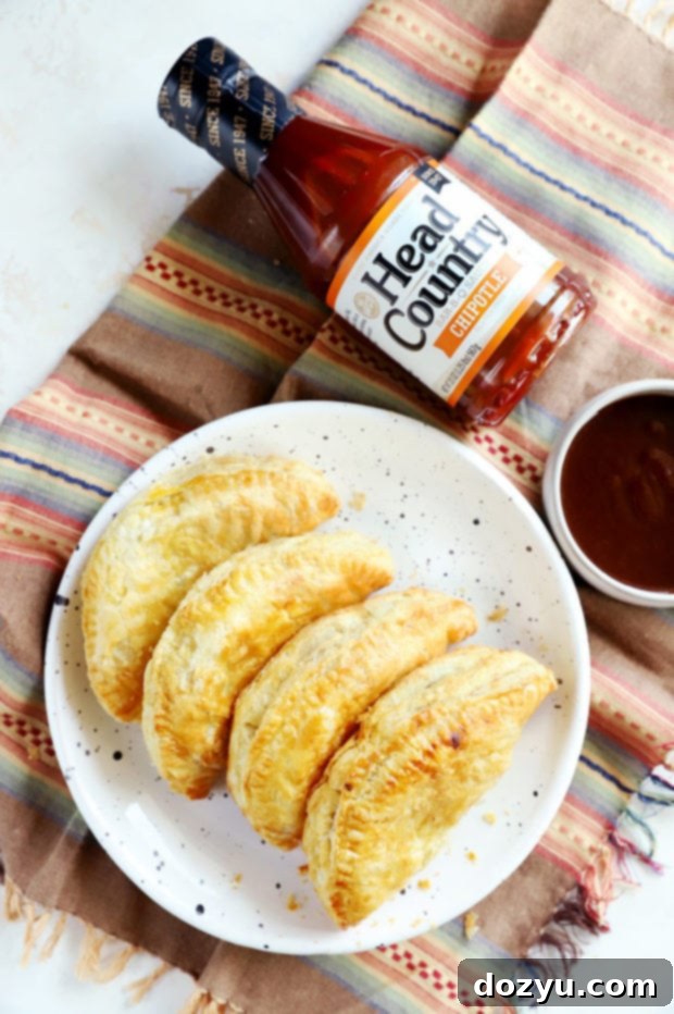 Overhead shot of empanadas on a plate with Head Country BBQ sauce bottle