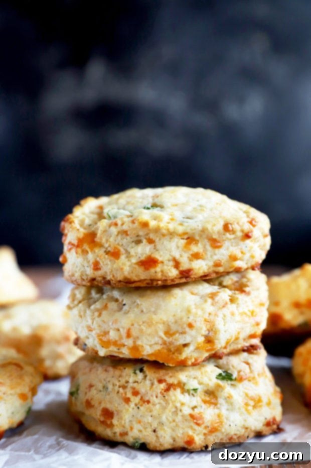 Freshly baked Jalapeño Cheddar Biscuits stacked on a wire rack, showing their golden brown tops and flaky texture.