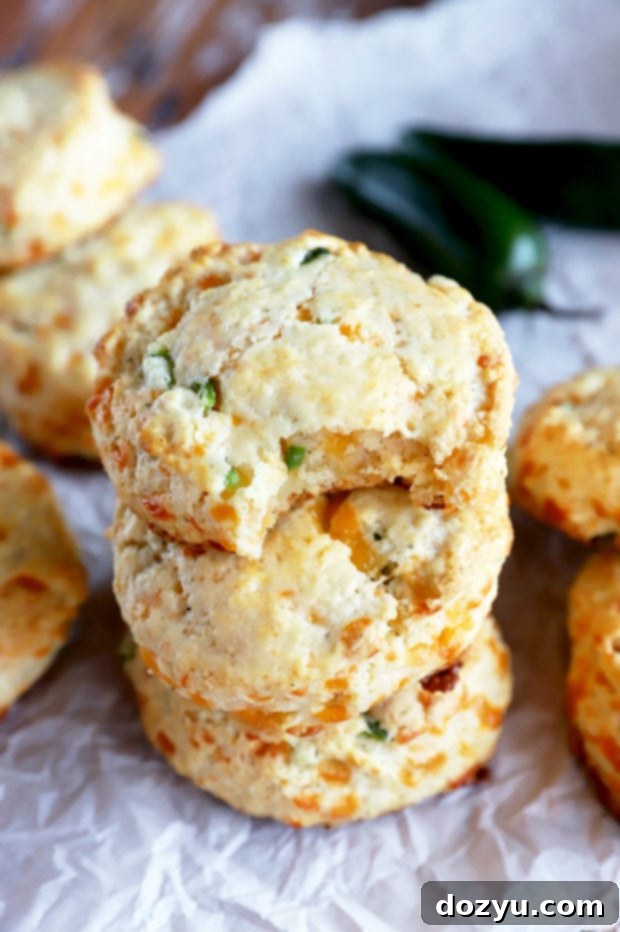 A close-up image of a Jalapeño Cheddar Biscuit with a bite taken out, revealing its soft, cheesy, and jalapeño-speckled interior.