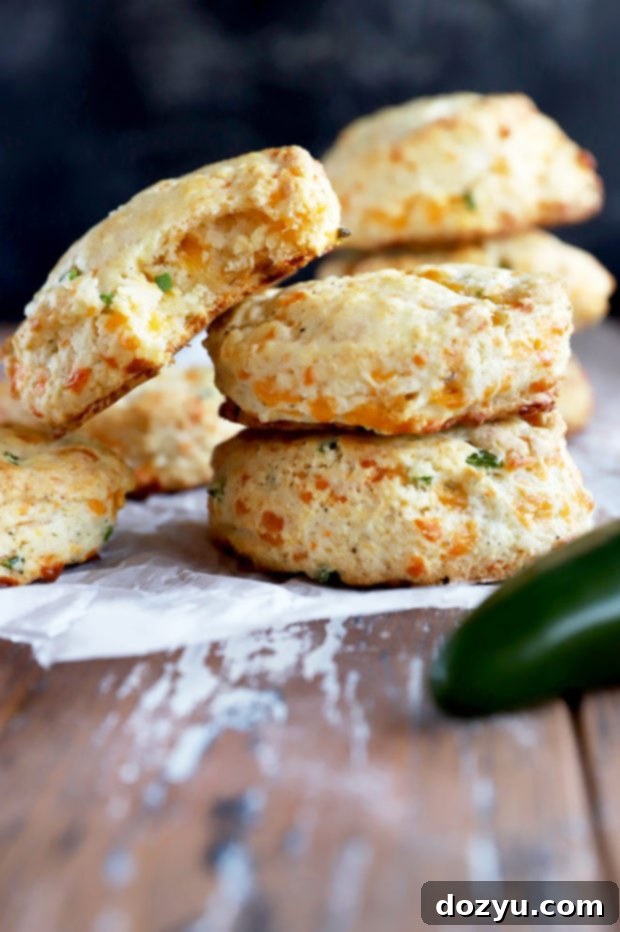 A stack of golden-brown Jalapeño Cheddar Biscuits showing their layered, flaky texture.