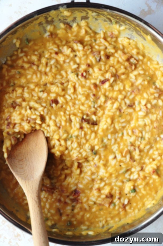 Risotto cooking in a large skillet, showing the creamy texture and gradual absorption of liquid.