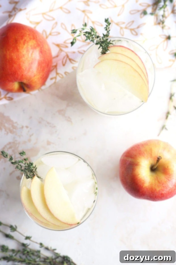 A vibrant display of Thyme Apple Gin and Tonic cocktails with fresh apples and thyme, perfect for autumn entertaining