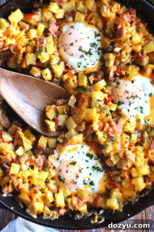 A cast iron skillet filled with colorful Southwestern Ham Hash, topped with perfectly cooked eggs and fresh cilantro, ready to be served.
