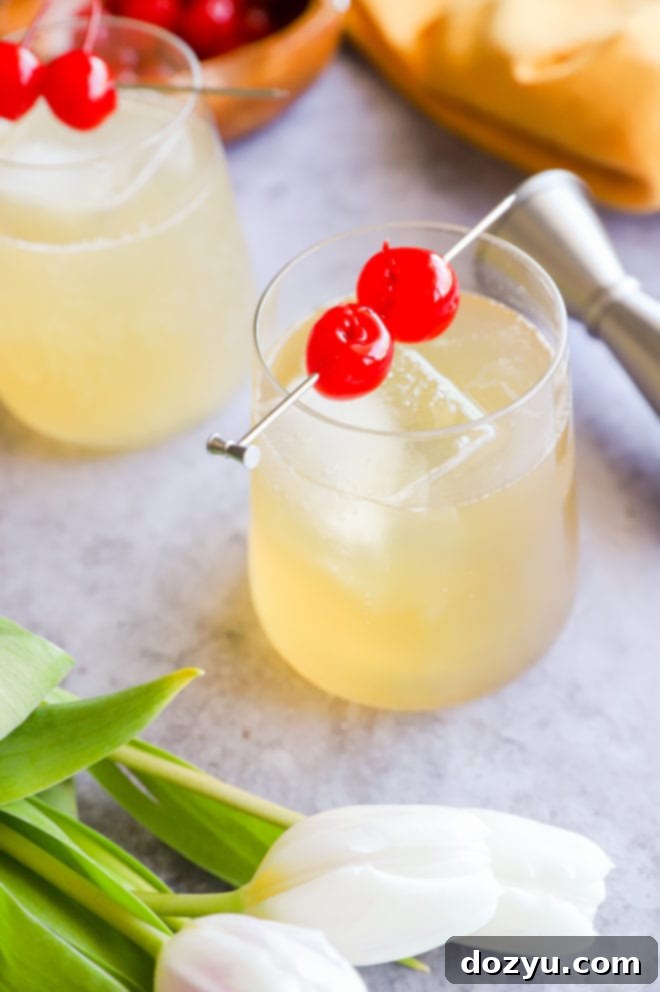 The Gilded Sparkler 4 White tulips next to a whiskey sour cocktail with cherry garnish