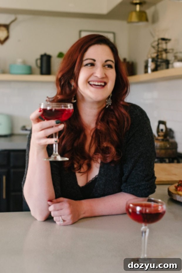 Meghan, the creator of Cake 'n Knife, smiling brightly and holding a kitchen utensil, symbolizing the blog's fresh start and welcoming atmosphere.
