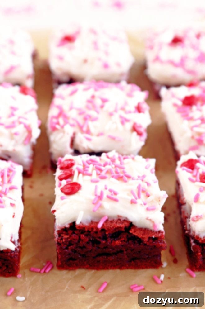 Rich Red Velvet Brownies topped with creamy Champagne Cream Cheese Frosting, arranged beautifully for a celebratory dessert.
