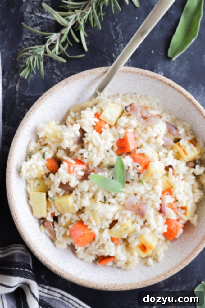 Overhead view of a beautifully plated roasted vegetable risotto, garnished with fresh herbs