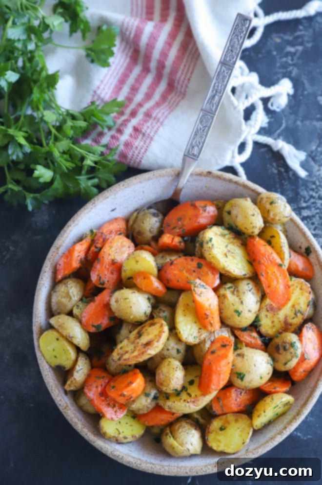 Golden Garlic Butter Roasted Carrots and Potatoes 4 A close-up shot of a bowl brimming with roasted carrots and potatoes, ready to be served.