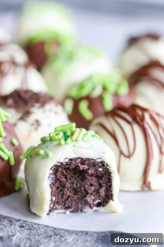 Decadent Oreo Bailey's Truffles 8 Bite taken out of a bailey's truffle revealing the dark, rich interior