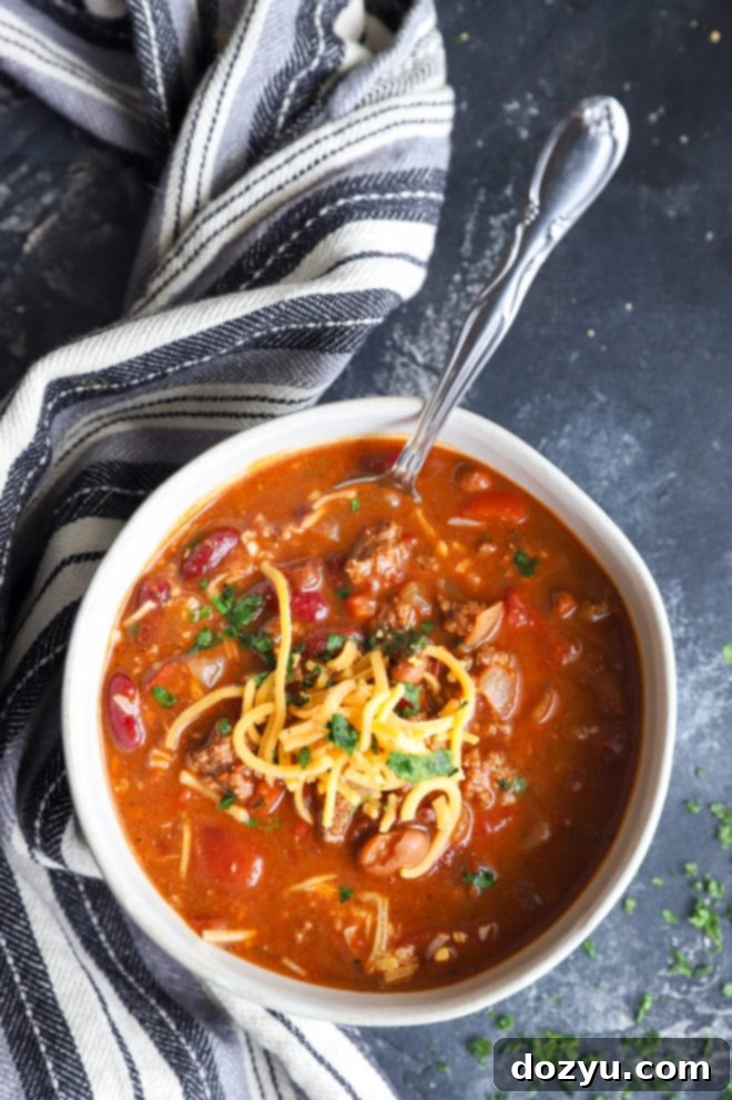 A bowl of rich, smoky chipotle chili, garnished with fresh cilantro and a dollop of sour cream, ready to be enjoyed.