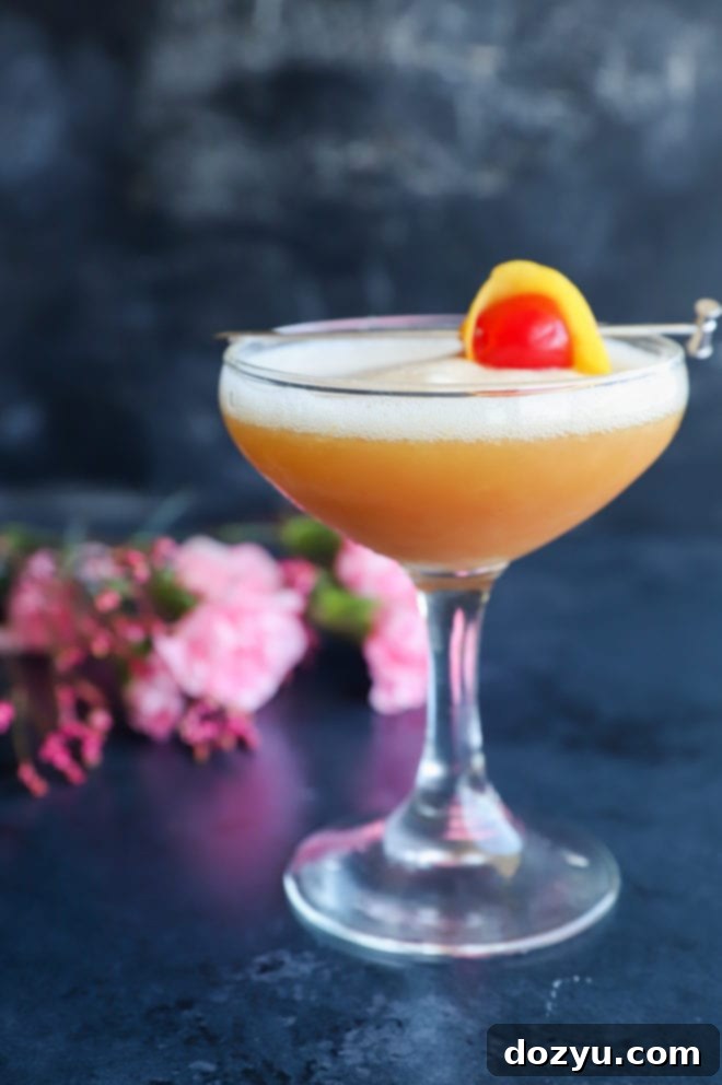 Boston's Spirited Zest 2 A perfectly crafted Boston Sour in a elegant coupe glass, showcasing its frothy top and amber hue.