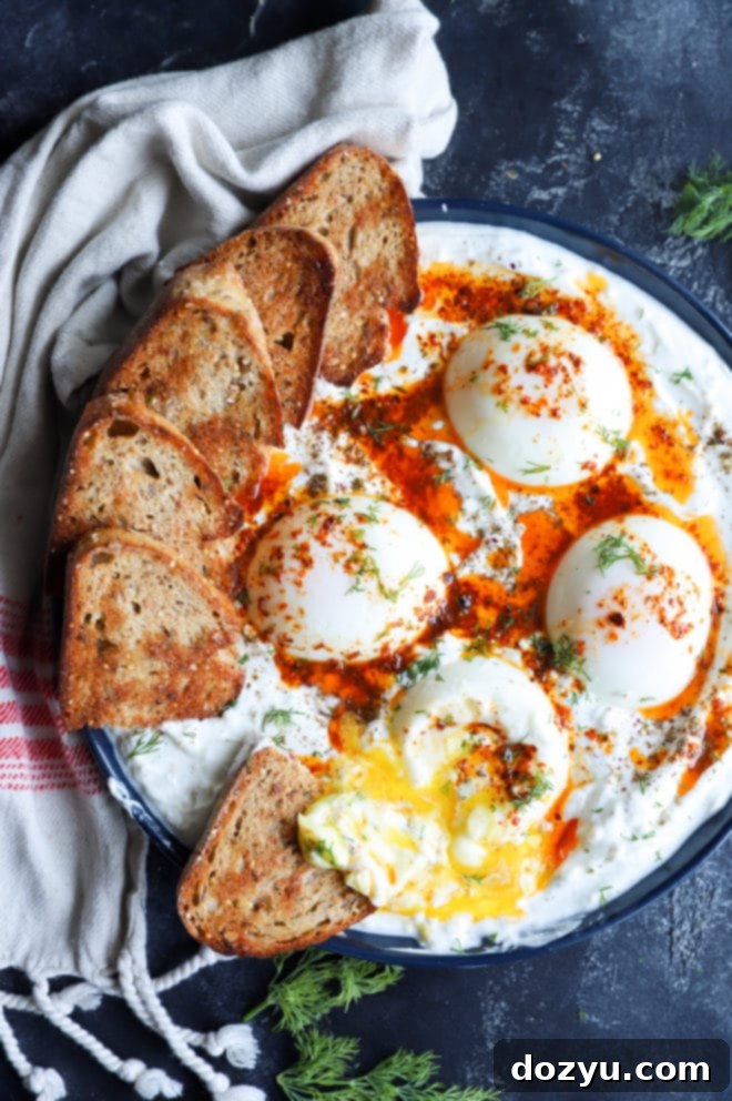 A beautifully presented Turkish Eggs platter with toasted bread slices arranged around the edges, ready for serving.