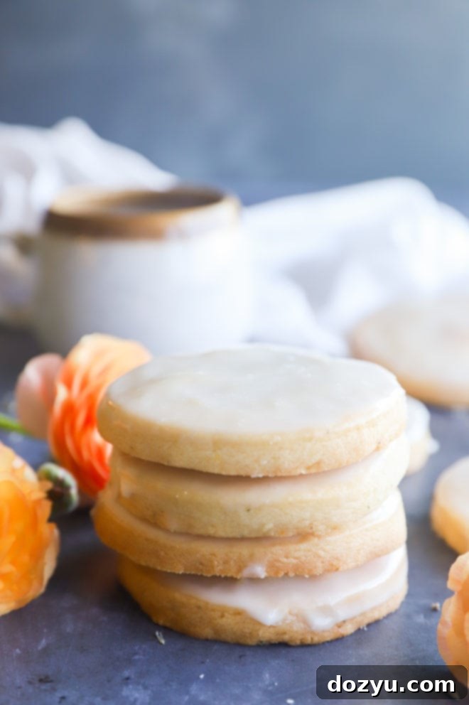 Lemon Lavender Shortbread Delights 3 A stack of perfectly glazed lemon lavender shortbread cookies, garnished with a sprig of fresh lavender, highlighting their inviting appeal.