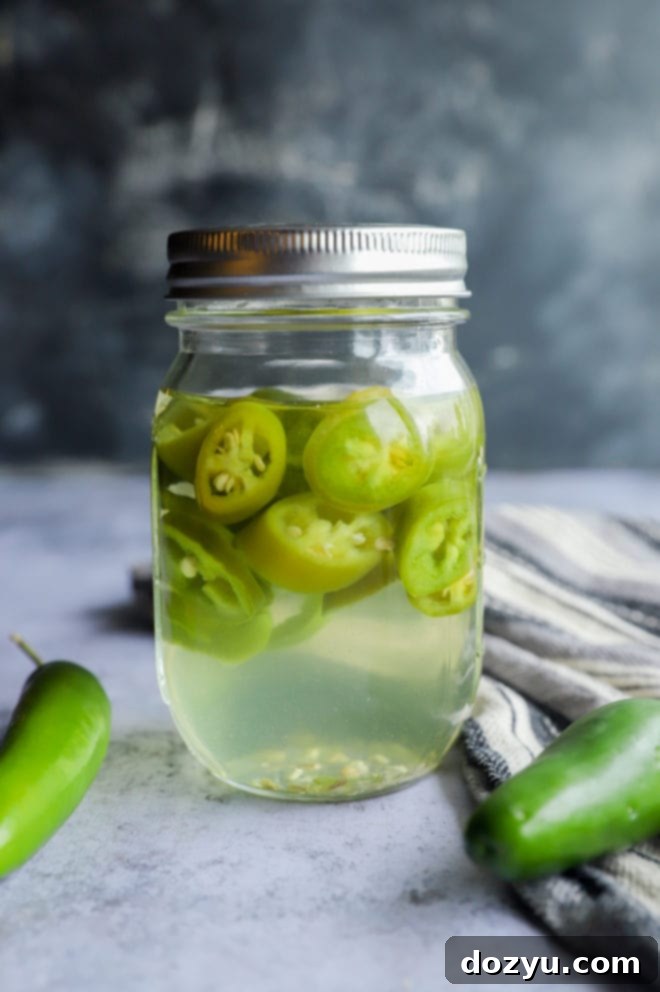 Mezcal infusion in a jar with peppers after 12 hours of steeping